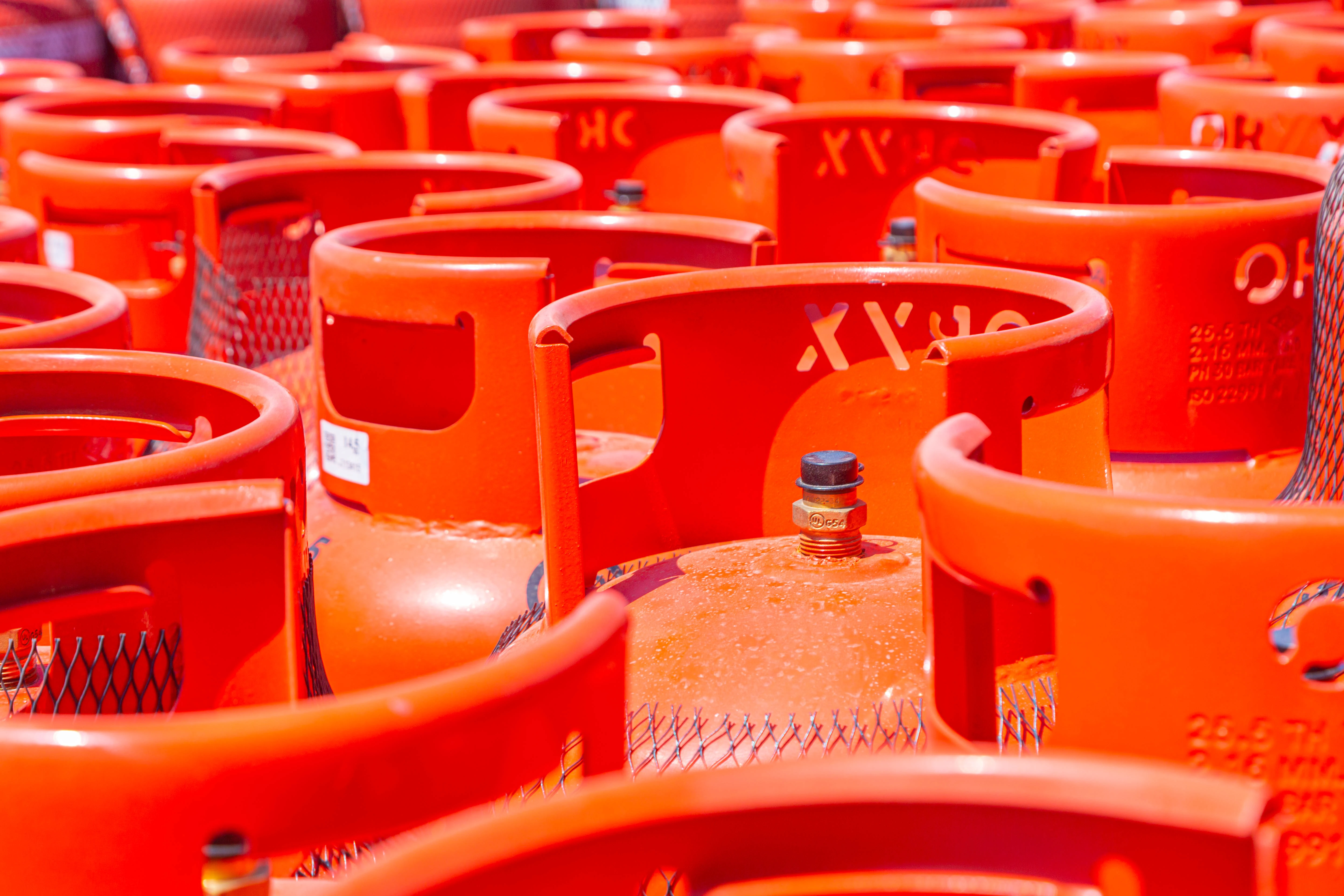 Rows of bright orange gas cylinders tightly grouped together.